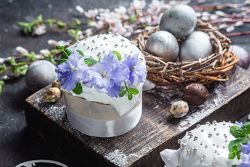 Easter cake with meringue and violets on a dark background