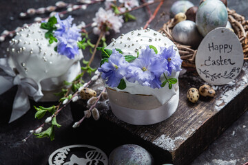 Fototapeta na wymiar Easter cake with meringue and violets on a dark background