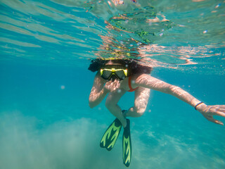 woman diving underwater in scuba mask and flippers