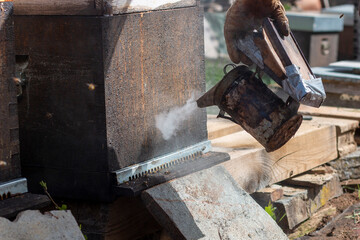 Beekeeping smoker. The beekeeper lighting it with different fuels and applying the smoke in the hives