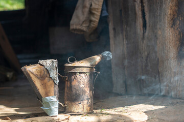 Beekeeping smoker. The beekeeper lighting it with different fuels and applying the smoke in the hives