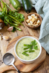 Vegan soup puree of green vegetables. Bowl of green bean and zucchini cream soup on a rustic table. Healthy diet low carb.