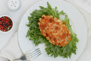 Pozharsky cutlets and lettuce leaf in a white plate on a marble background. Selective focus, top view - 593938469