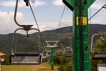 Mountain yellow lift on a summer day over the mountains. Old ski lift in the mountains in the sun. Carpathians, Ukraine.