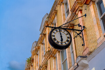 Close-up details of an old city clock on a brick house in the downtown of Bromley City - London