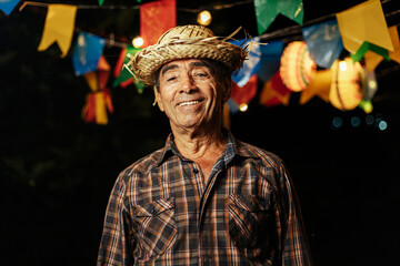 Senior man celebrating the Brazilian Festa Junina. Portrait of a man wearing typical clothes and a...
