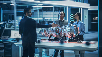 Fototapeta na wymiar Smart Team of Engineers, Project Manager and Machinery Operators Collaborate on a New Type of a Electric Turbine Engine, Standing with Tablet and Laptop Computers in Scientific Technology Lab.