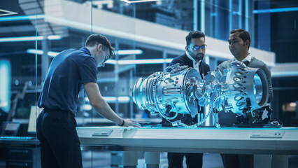 Software Developer, Project Manager and Machinery Operators Collaborate on a Prototype Turbine Engine, Standing with Laptop Computer in Scientific Technology Lab. Team Developing a New Electric Motor © Gorodenkoff