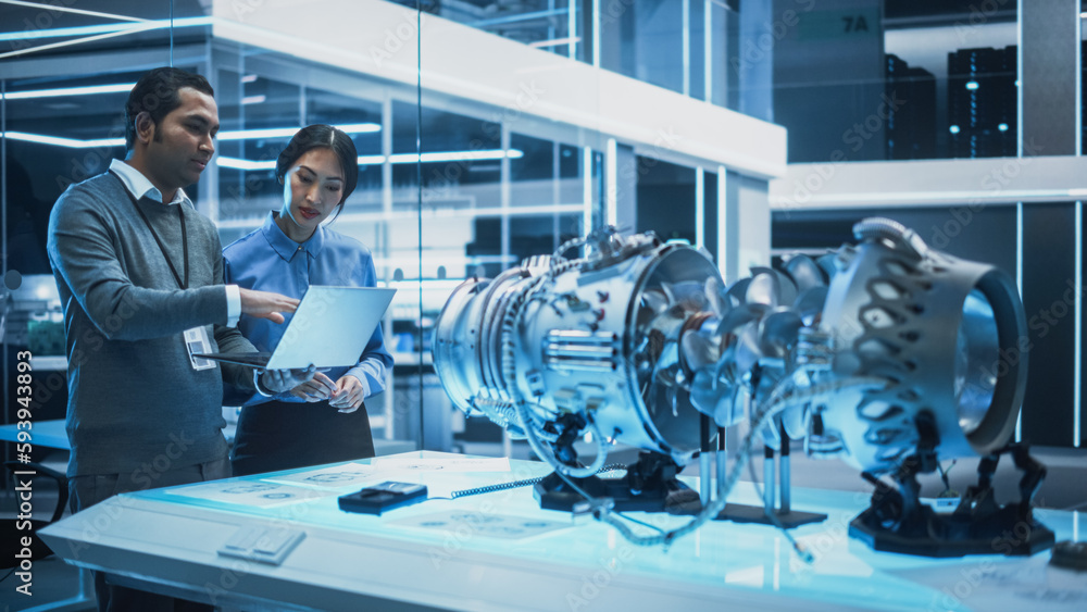 Poster two multiethnic employees work in modern innovative research facility with a futuristic jet engine. 