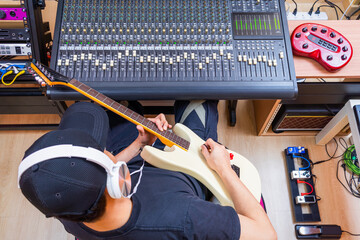 top view of male musician enjoy playing and recording electric guitar in home studio
