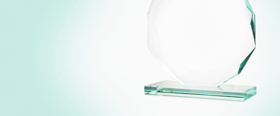 Closeup of an award made of thick cut glass with highlights on white background. Glass trophy, blank