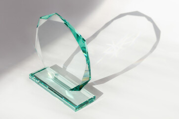 Close-up of thick glass award with highlights and shadow on white background. Glass trophy, template