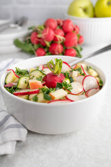 Radish salad with cucumber and apples in a bowl
