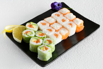 Assortiment de california rolls et maki sur un fond blanc. Cuisine japonaise