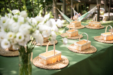 Side view of a table with many wooden linen baskets for floral arrangement, floristic workshop for kids.