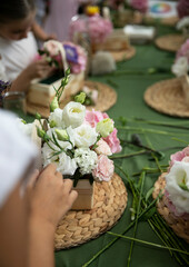 Frame image of a hand making floral arrangements at a floristry masterclass, details on flowers.
