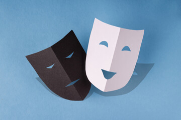 paper theater masks with shadow on a blue background, photo