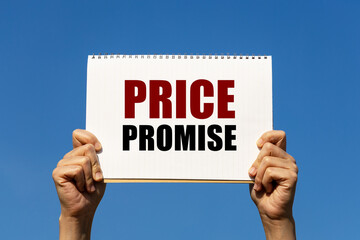 Price promise text on notebook paper held by 2 hands with isolated blue sky background. This message can be used as business concept about price.