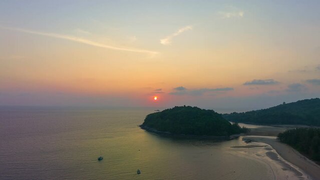 aerial hyperlapse the sun above Kala island at Layan beach Phuket..colorful sky of sunset at horizon.Phuket beach sea Amazing beach, .Beautiful beach Phuket Thailand, Nature and travel concept.