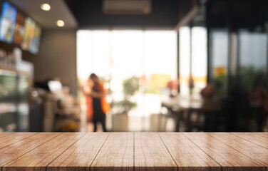 Empty wooden table top with lights bokeh on blur restaurant background.