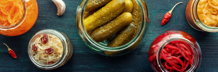 Fermented food panorama, shot from above. Homemade vegetable preserves. Sauerkraut, pickles, kimchi etc in glass jars. Healthy probiotic diet