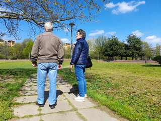 Due anziani a passeggio nel parco urbano