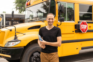 Portrait of young teacher near the school bus