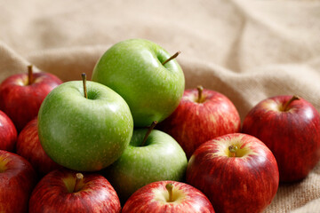 Fresh red and green apples on sack background