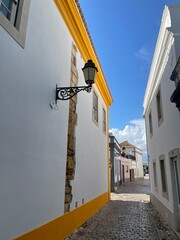 Petite ruelle pavée dans la vieille ville de Faro, avec ses maisons bien entretenues dont une au...