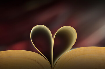 Heart shaped book pages and abstract red tone background
