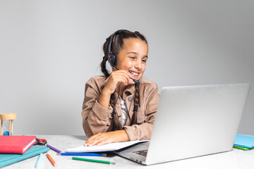 Online Education. Cute little Girl Study At Home With Laptop And Wireless Headphones, Adorable Kid Having Web Lesson With Teacher, Enjoying Distance Learning During Quarantine Time, Free Space