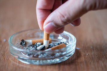 man hand extinguish the cigarette in the ashtray , stop smoking concept