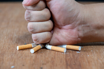man hand hit on cigarette, stop smoking sign concept