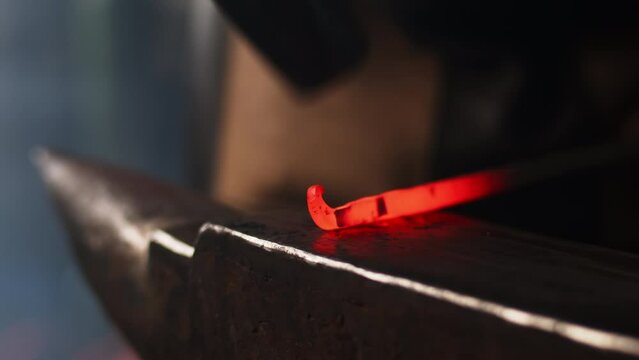 Blacksmith working a red hot iron from a forge in an artisanal workshop