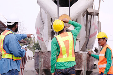 Workers and cement mixer at construction site.
