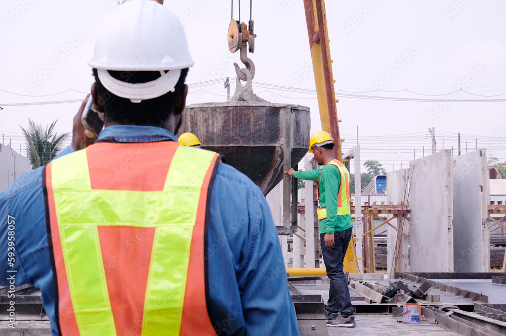 Wall mural engineers and workers pouring cement at construction site.