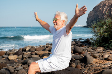 Vacation Retirement Lifestyle concept at Sea, Happy Senior Man Sitting Relaxing at Beach - Stilish Elderly Grandfather Enjoying Free time