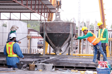 Workers are pouring cement to work at a construction site.