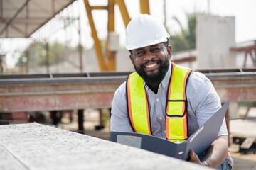 African American engineer man working with document at precast site work	