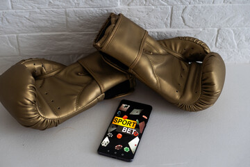 boxing gloves and smartphone with bets.