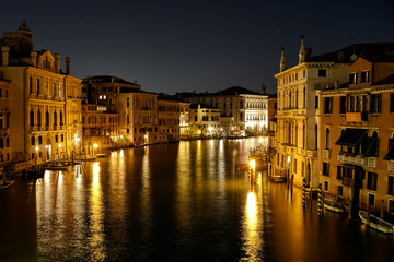 Obraz premium Venice, Italy: Night view of Venice Grand Canal with boats and Santa Maria della Salute church on sunset from Ponte dell'Accademia bridge. Venice, Italy