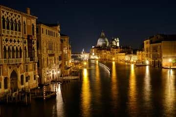 Venice, Italy: Night view of Venice Grand Canal with boats and Santa Maria della Salute church on sunset from Ponte dell'Accademia bridge. Venice, Italy
