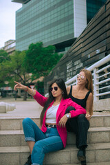 Fototapeta na wymiar mujeres latinas disfrutando de un día al aire libre señalando un lugar hacia adelante 