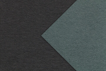 Texture of black paper background, half two colors with dark green arrow, macro. Structure of craft olive cardboard.