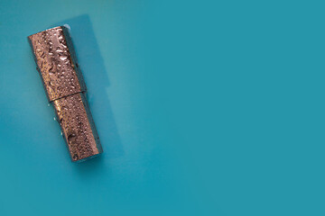 Lipstick in drops on a blue background, care cosmetics, makeup