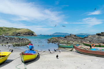 Beautiful Praia do Forte S&atilde;o Mateus in Cabo Frio, with the sea water around it, many fishing boats, beautiful sky with clouds and mountains in the background.