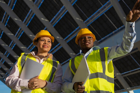 Building workers with folders and laptop discussing panel installation