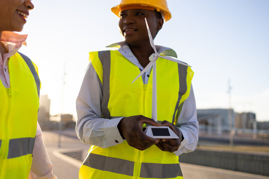 Black engineers with wind turbine on construction site