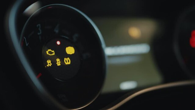 Close up of RMP tachometer turning on, numbers from one to seven lightning up, arrow coming to seven and back. Blurred auto screeen in background