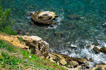 Rocks at Praia dos Foguetes, close to the city of Cabo Frio, blue sea and surrounding vegetation.